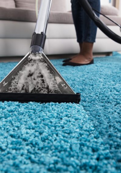 Person Using Vacuum Cleaner For Cleaning Carpet
